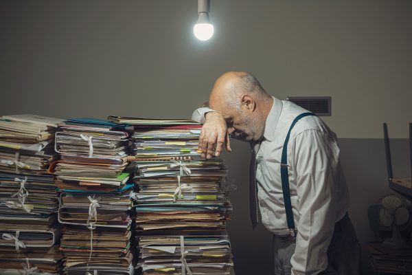 a desk piled high with files and paperwork